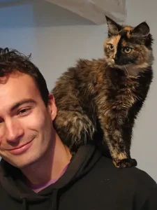 Mettez "Marlon, fondateur de Mon Chat Écaille, avec sa chatte sur l'épaule".